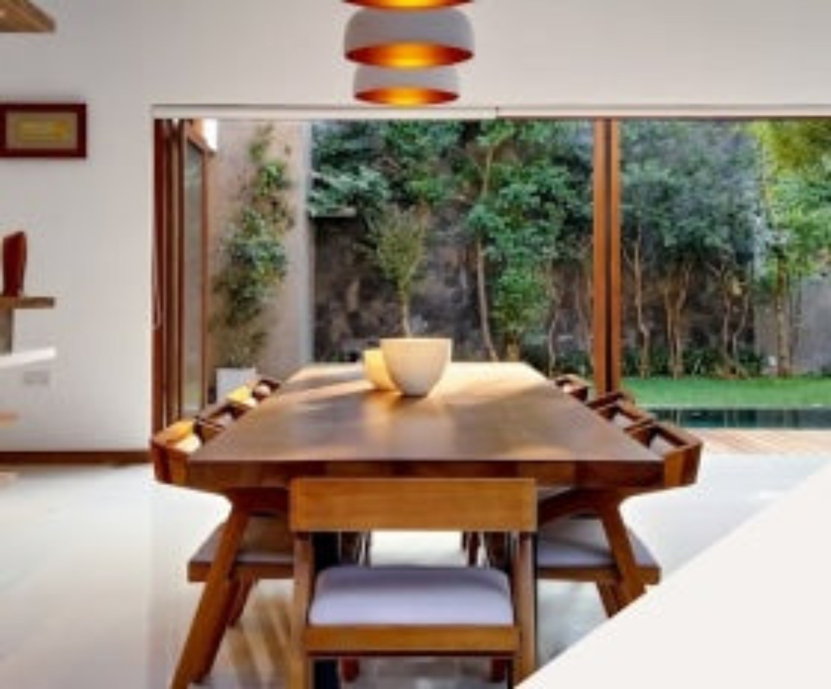 A dining room featuring a wooden table surrounded by four chairs, elegantly set for a meal.